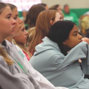 A photo of several high school girls side profiles as they listen intently to a presentation.