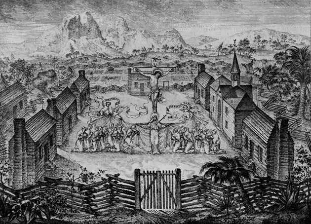 A drawing from a European artist of a mystical rendition of a area with many houses and a church, with palm trees and mountains in the background. There is a giant crucifix in the middle of the town square with people bowing down.