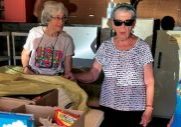 Three older women are pictured standing and talking as they volunteer with a food pantry in new Mexico.